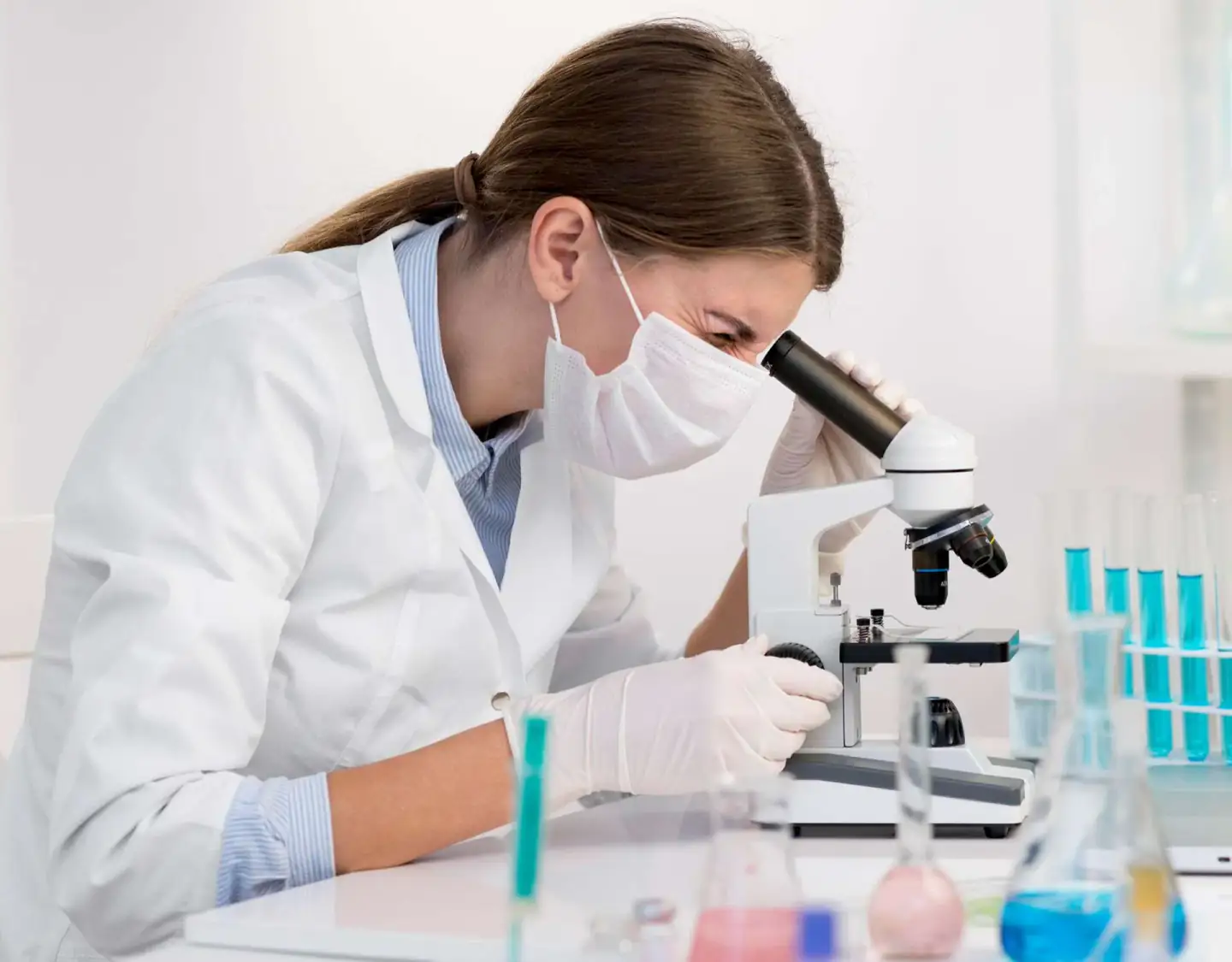 Laboratory researcher reviewing a sample under a microscope